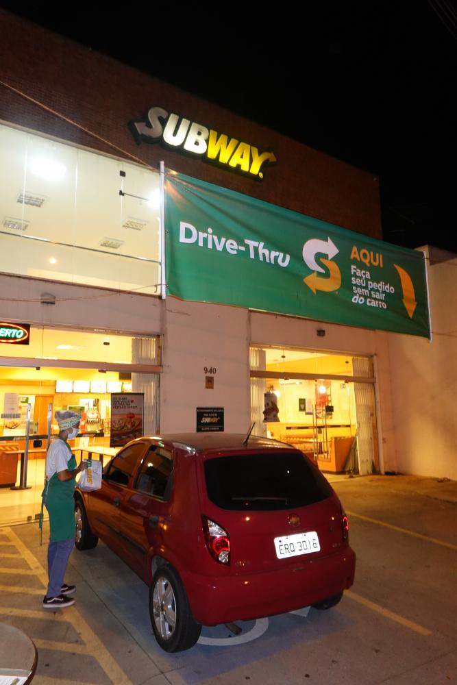 Atendente entrega pedido no estacionamento da loja Subway da Avenida da Saudade