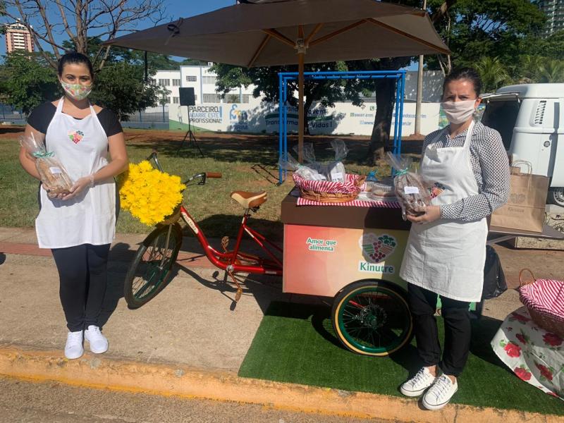 Rosangela Cândido (dir.) e a assistente e Stephanie Siqueira, com sua Bike Food Kinutre, na Feira Drive Thru