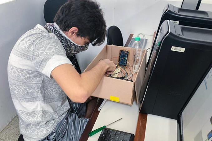 Estudante Sergio Duarte finalizando totem que facilita higienização das mãos e realiza contagem de pessoas em determinado local