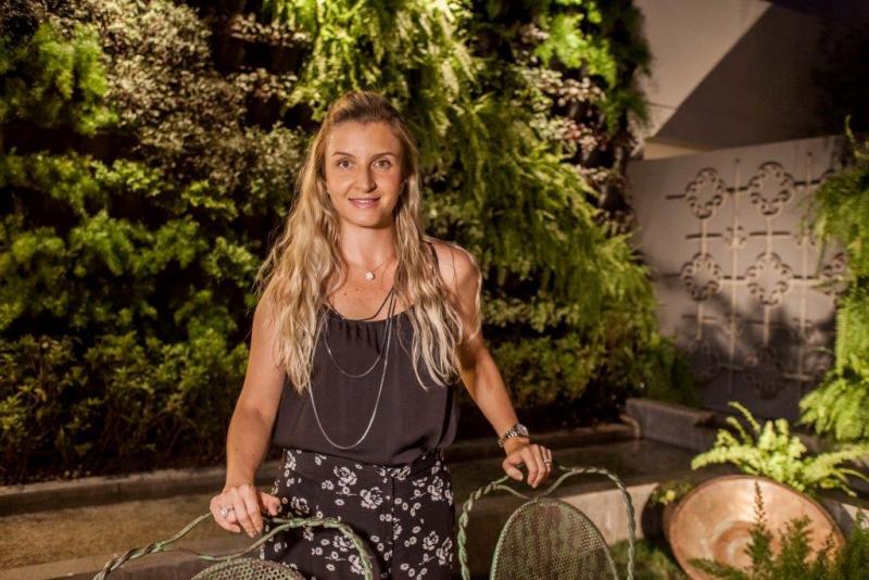 A arquiteta e paisagista Giovana Sartori diante de um de seus projetos de jardins verticais: tendência sustentável 