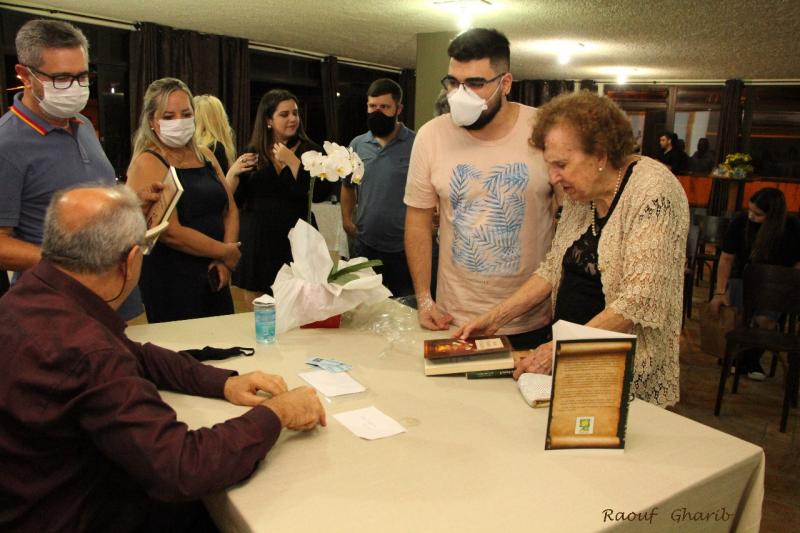 Momento em que Daltozo autografa os livros para o público