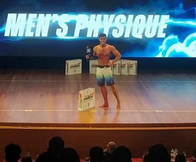 No palco, após receber o troféu de campeão, na categoria Mens Physique Junior