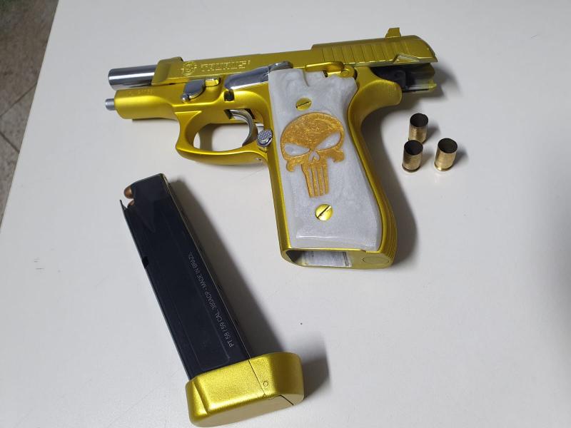 Arma personalizada na cor dourada da qual as testemunhas apresentaram três cartuchos deflagrados