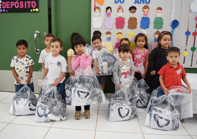 Garotada com os kits para começar o ano letivo