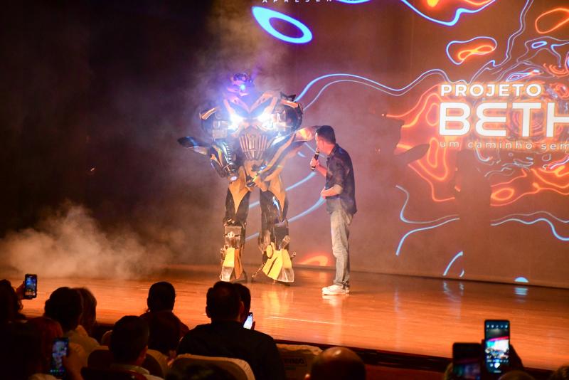 Marcos Palhares subiu ao palco pela primeira vez fantasiado de robô gigante; foi apresentado pelo designer instrucional Antônio Sérgio de Oliveira