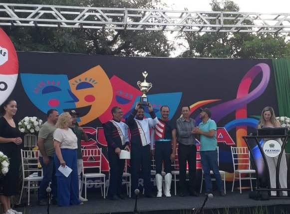 Momento e que os professores recebem o troféu de Corporação Revelação do festival