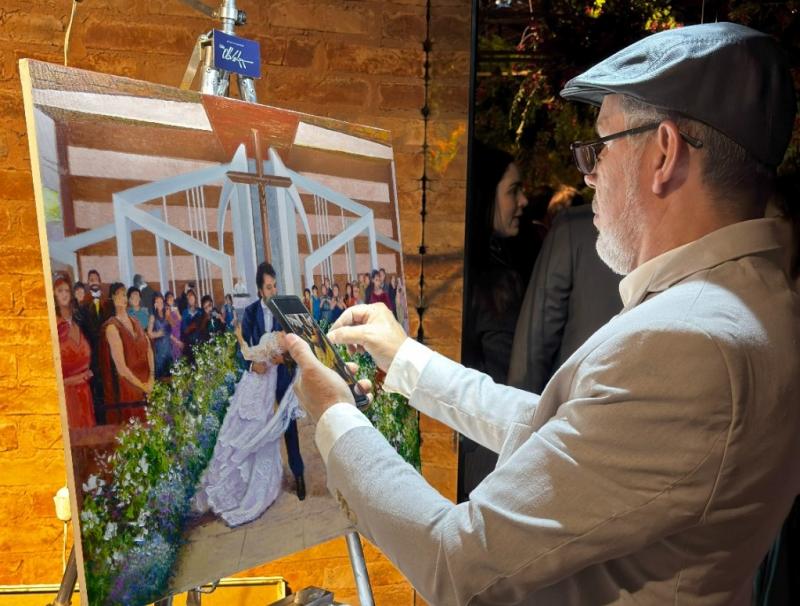 O artista plástico, Cido Oliveira, retratando o casamento em óleo sobre tela, durante a cerimônia na Igreja Menino Jesus de Praga