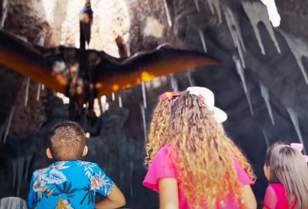 Crianças conhecendo o pteranodon, guardião do vulcão