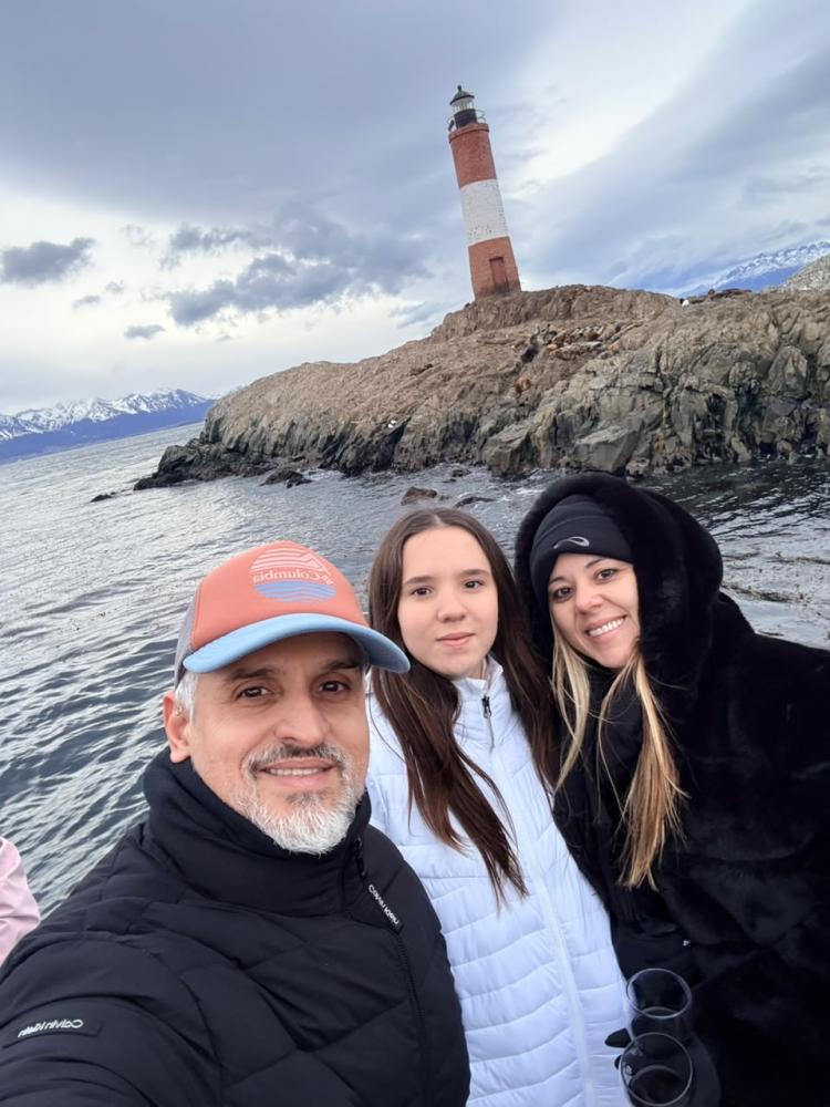 DIGO CAVALCANTE, A ESPOSA CAROLINE E A FILHA MARIA LUIZA POSAM DIANTE DO EMBLEMÁTICO FAROL LES ÉCLAIREURS, QUE GUIA NAVEGADORES NAS ÁGUAS GELADAS DO CANAL BEAGLE
