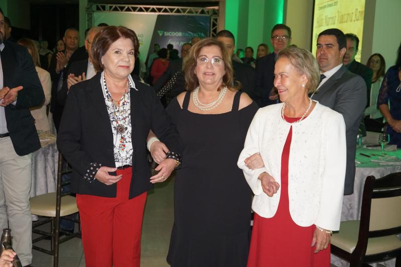 Antonia Jacinto Bergamo, diretora da Acipp, e Maria das Graças Ferraz, do Sincomércio, conduziram a homenageada à mesa principal