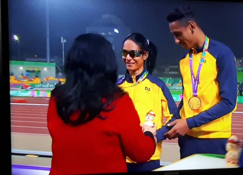 Reprodução: Momento em que Jerusa e Gabriel recebem a medalha de ouro pelos 100m