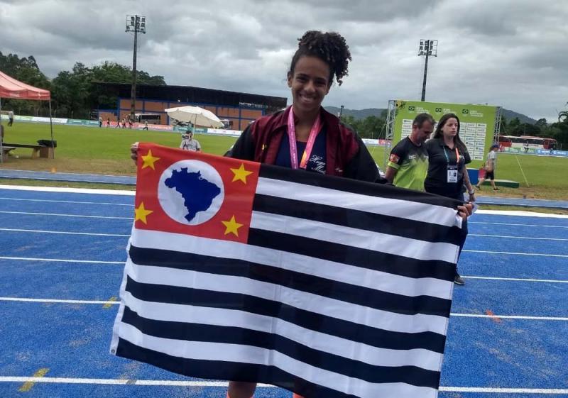 Organização JEJ - Com a bandeira de PP, Allana sorri no pódio por sua medalha de prata pela seleção paulista