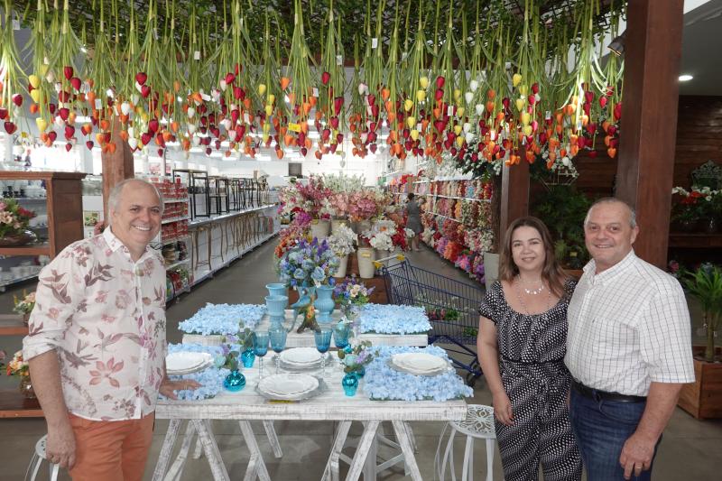 Rita e Aldir Dalefi inauguram o novo jardim de flores artificiais da loja Multi-Itens, ao lado do designer Eder Felito, autor do projeto