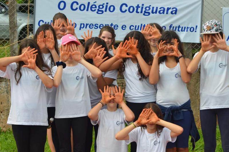 Alunos do Colégio Cotiguara participantes da ação ambiental de ontem, plantando mudas de árvores em área verde da Avenida Juscelino Kubitschek