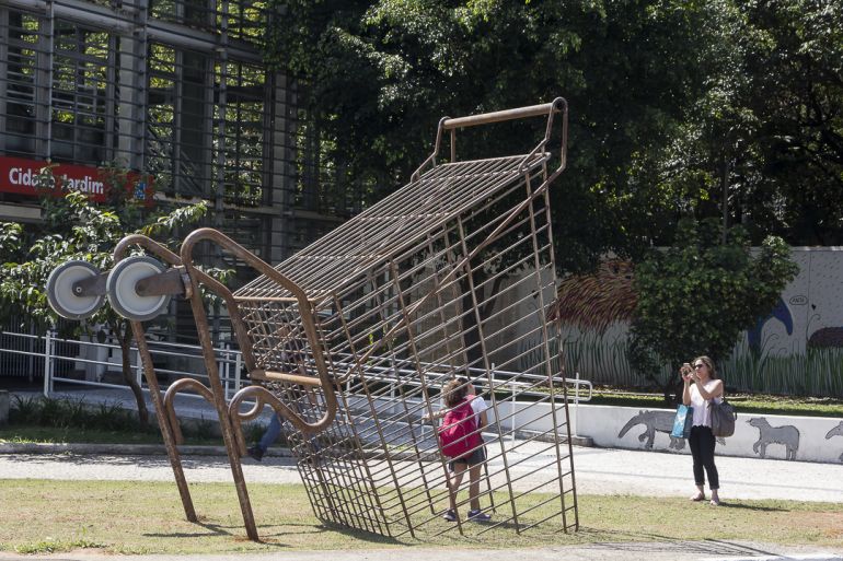 Divulgação - “Mercado”, de Eduardo Srur, um carrinho realista de 3,5 metros de altura enterrado na grama